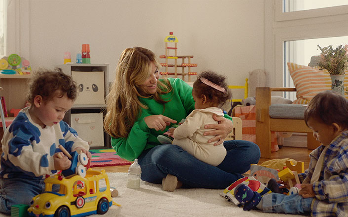 Photo de l'assistante maternelle entourée de trois enfants
